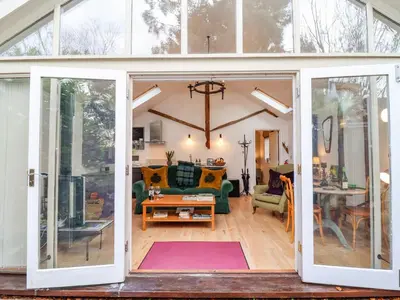 an open living room with sliding glass doors at The Bothy at Snape Hall in Snape