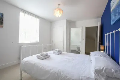a bedroom with a white bed with towels on it at The Gallery, Blythburgh in Blythburgh