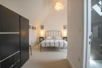 a bedroom with a bed and a chandelier at The Gallery, Blythburgh in Blythburgh