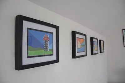 a group of framed pictures hanging on a wall at The Gallery, Blythburgh in Blythburgh