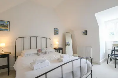 a bedroom with a large bed with towels on it at The Gallery, Blythburgh in Blythburgh