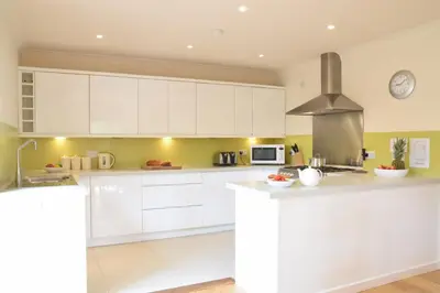 a kitchen with white cabinets and a stove at Peach House, Aldeburgh in Aldeburgh