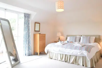 a bedroom with a bed and a large window at Peach House, Aldeburgh in Aldeburgh
