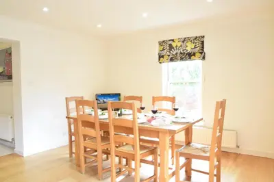 a dining room table with chairs and a laptop on it at Peach House, Aldeburgh in Aldeburgh