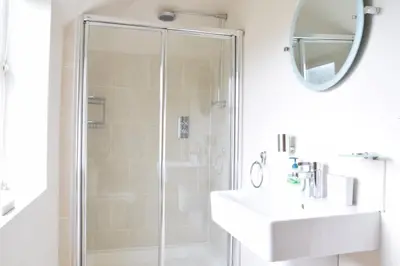 a bathroom with a shower and a sink and a mirror at Peach House, Aldeburgh in Aldeburgh