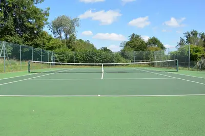 a tennis court with a net on top of it at Stable Cottage at the Grove, Great Glemham in Framlingham