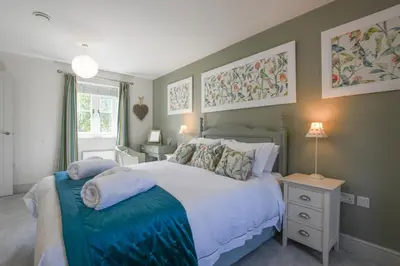 a bedroom with a large bed with pillows on it at 1 Coconut Cottage, Long Melford in Long Melford
