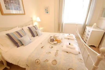 a bedroom with a bed with a tray of food on it at High Tide, Crabbe Street, Aldeburgh in Aldeburgh