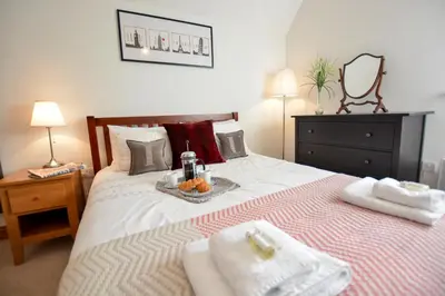 a bedroom with a bed with towels on it at Three Chantry Barns, Orford in Orford