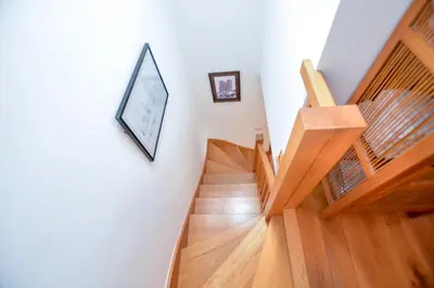 a staircase with wooden floors and a picture on the wall at Three Chantry Barns, Orford in Orford