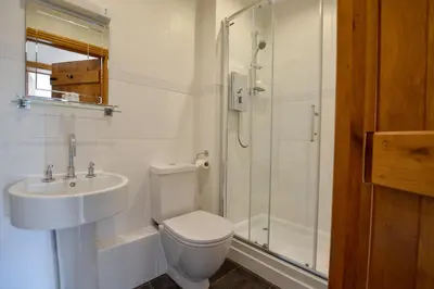 a bathroom with a toilet and a sink and a shower at Three Chantry Barns, Orford in Orford