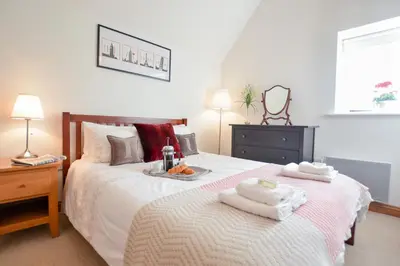 a bedroom with a bed with two towels on it at Three Chantry Barns, Orford in Orford