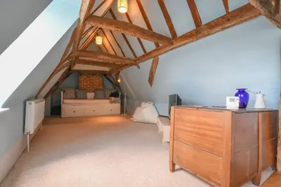 a attic room with a dresser and a bed at Beresford House in Woodbridge