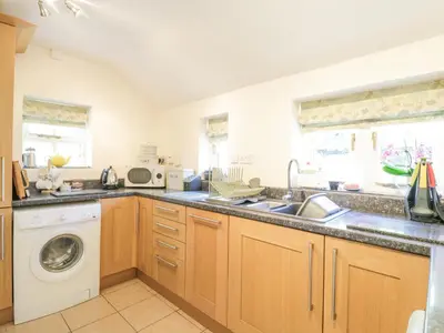 a kitchen with a sink and a washing machine at Shoemakers Cottage, Friston in Friston