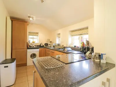 a large kitchen with a counter top and a sink at Shoemakers Cottage, Friston in Friston