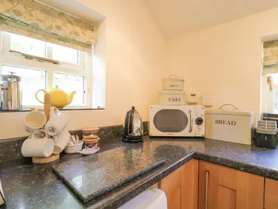 a kitchen with a counter top with a microwave at Shoemakers Cottage, Friston in Friston
