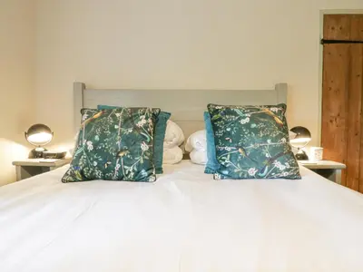a bedroom with a white bed with two pillows at Shoemakers Cottage, Friston in Friston
