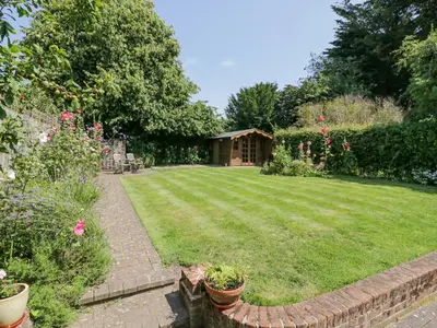 a garden with a house in the background at Shoemakers Cottage, Friston in Friston