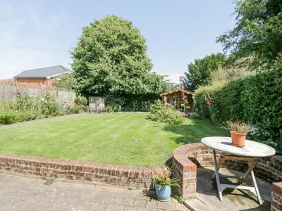 a small garden with a table and a lawn at Shoemakers Cottage, Friston in Friston