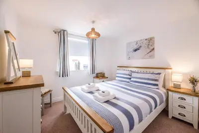 a bedroom with a bed with two towels on it at Coasters, Aldeburgh in Aldeburgh