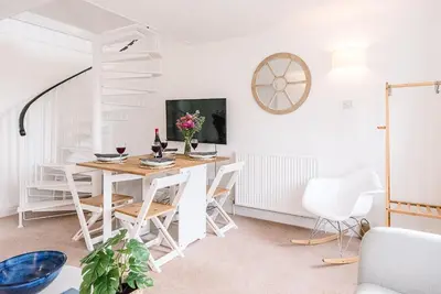a white dining room with a table and chairs at Coasters, Aldeburgh in Aldeburgh
