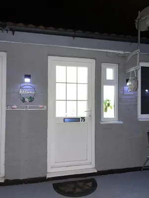 a garage with a white door and two windows at Newly refurbished modern 2 bedroom flat in Trimley Heath