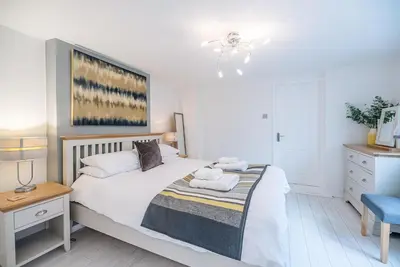 a bedroom with a bed with two towels on it at The Apartment at Clare House, Aldeburgh in Aldeburgh