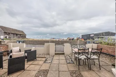 a patio with chairs and a table on a balcony at The Apartment at Clare House, Aldeburgh in Aldeburgh