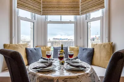 a table with two glasses of wine on it at The Apartment at Clare House, Aldeburgh in Aldeburgh