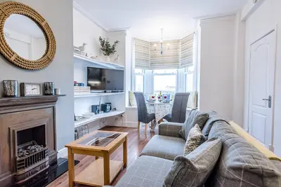 a living room with a couch and a fireplace at The Apartment at Clare House, Aldeburgh in Aldeburgh