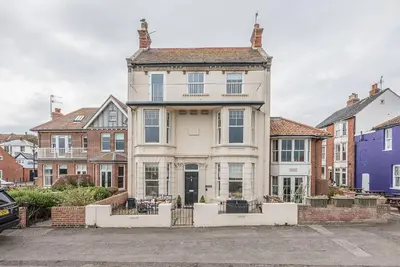 a large white house in a parking lot at The Apartment at Clare House, Aldeburgh in Aldeburgh