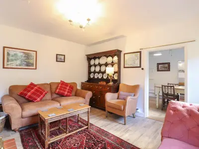 a living room with a couch and a table at Warren Cottage in Leavenheath