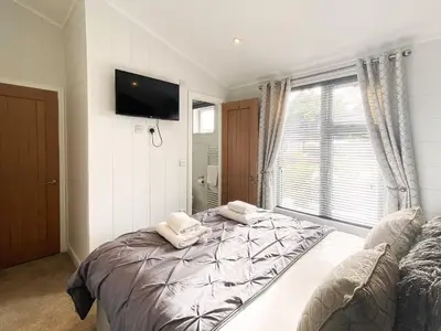 a bedroom with a bed with two pillows on it at Alde Lodge by The Suffolk Cottage Collection in Aldeburgh
