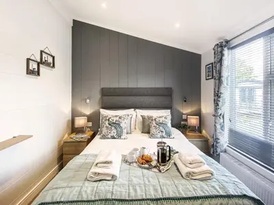 a bedroom with a bed with two towels on it at Alde Lodge by The Suffolk Cottage Collection in Aldeburgh