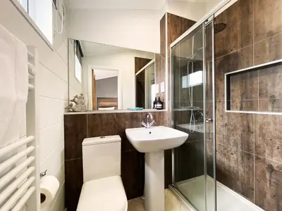 a bathroom with a toilet and a sink and a shower at Alde Lodge by The Suffolk Cottage Collection in Aldeburgh