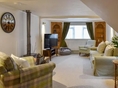 a living room with couches and a flat screen tv at The Old Butcher's Shop in Wereham