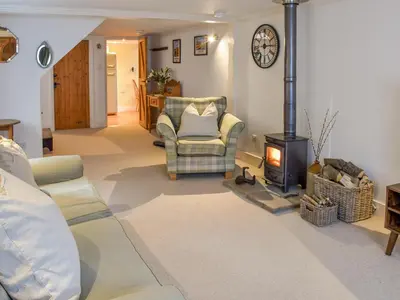 a living room with a couch and a wood stove at The Old Butcher's Shop in Wereham