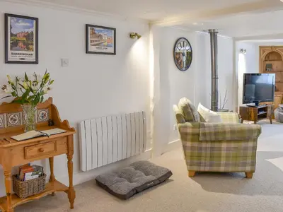 a living room with a tv and a chair and a table at The Old Butcher's Shop in Wereham