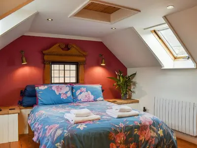 a bedroom with a blue bed with towels on it at The Old Butcher's Shop in Wereham