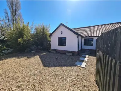 a house with a fence in a yard at Middle Tree, ideal modern cottage in Alburgh