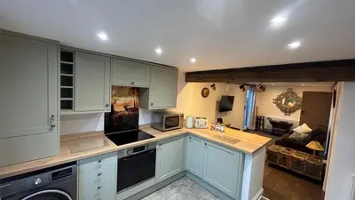 a kitchen with blue cabinets and a living room at Middle Tree, ideal modern cottage in Alburgh