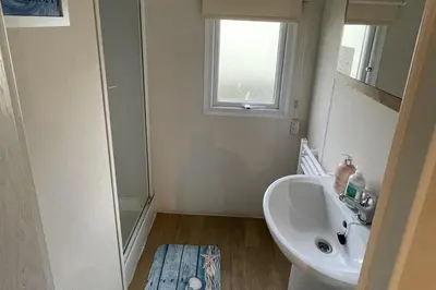 a small bathroom with a sink and a window at Caravan - Sleeps 10 - Pet friendly - Parking in Clacton-on-Sea
