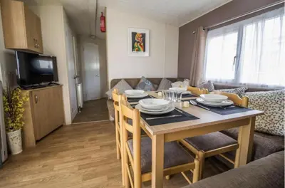 a dining room and living room with a table and chairs at Caravan - Sleeps 10 - Pet friendly - Parking in Clacton-on-Sea
