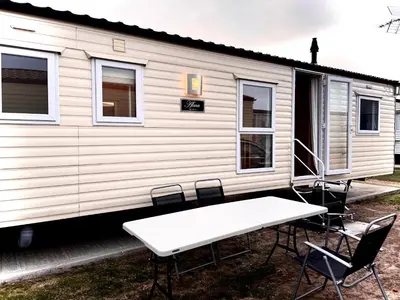 a table and chairs in front of a mobile home at Caravan - Sleeps 10 - Pet friendly - Parking in Clacton-on-Sea