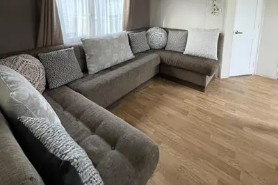 a living room with a couch and a wooden floor at Caravan - Sleeps 10 - Pet friendly - Parking in Clacton-on-Sea