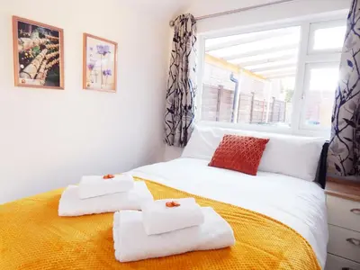 a bedroom with a bed with towels on it at Modern, well located en-suite rooms with parking - Orbitat Accommodations in Cambridge