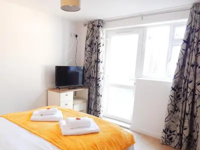 a bedroom with a bed with towels on it at Modern, well located en-suite rooms with parking - Orbitat Accommodations in Cambridge