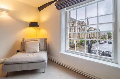 a room with a window with a chair and a lamp at Crown Street in Bury Saint Edmunds