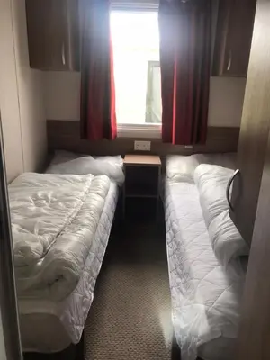 a small bedroom with two beds and a window at Swift Loire (Field view 78) in Jaywick Sands