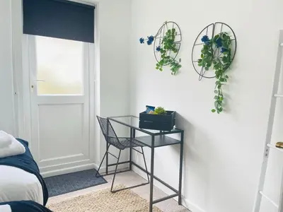 a room with a table and a chair next to a door at Cambridge Stay Cozy home with Wi-Fi, Parking Perfect for 2 in Cherry Hinton